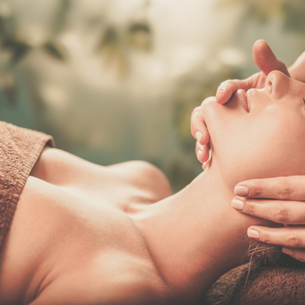 Young woman having face massage in a spa salon