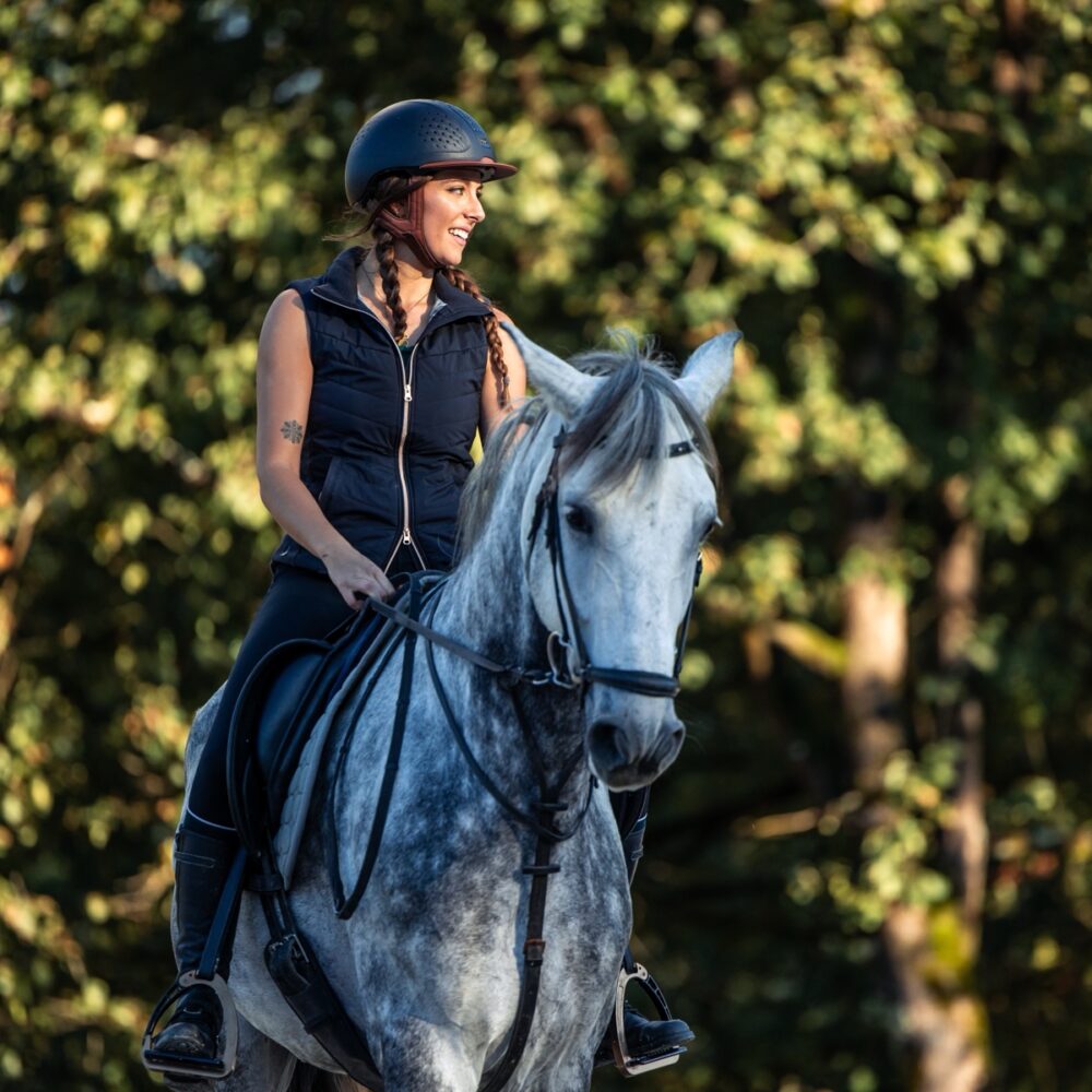 Copyspace,Young,Woman,Wearing,A,Riding,Helmet,Enjoys,A,Peaceful copyspace young woman wearing a riding helmet enjoys a peaceful ride on her horse through the serene forest at sunset. The warm golden light filters through the trees, casting a soft glow on the scene